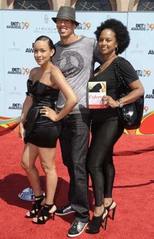 Football player Doug Christie poses with family. the woman on the right is downright hawking some book on the BET red carpet!! Wow, now that is tacky!